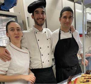 three chefs standing next to each other in a kitchen at B&B l'Angolo di Rosina con ristorante in Novello