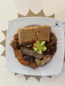 a plate of food with a sandwich and vegetables at Résidence Cheikh Mahy Cisse Appartements, studios et chambres a louer meublé et climatisé in Kaolack
