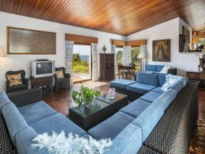 a living room with blue couches and a television at Stunning Oceanview Algarve Villa 9 Bedrooms Villa Quinta Marinha Amazing Location Overlooking Sea & Huge Pool Benagil in Lagoa
