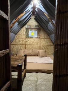 ein Bett in einer Jurte mit Fenster und Tisch in der Unterkunft Serene Farmhouse Retreat in Alfonso, Cavite - Perfect for Family Getaways in Alfonso