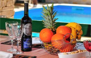 a table with a basket of fruit and a bottle of wine at Gorgeous Apartment In Sukosan in Sukošan +15 photos