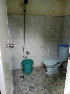 ein Badezimmer mit Toilette und grünem Eimer in der Unterkunft Serene Farmhouse Retreat in Alfonso, Cavite - Perfect for Family Getaways in Alfonso