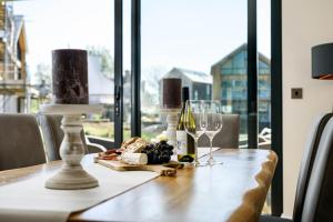 a table with wine glasses and a plate of food at Robins Retreat ML55 Lower Mill Estate Cotswolds in Somerford Keynes