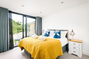a bedroom with a bed with a yellow bedspread at Robins Retreat ML55 Lower Mill Estate Cotswolds in Somerford Keynes +29 photos