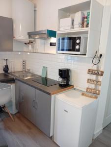 a kitchen with white cabinets and a counter top at Modern apartment! in Hazebrouck