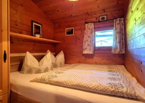 ein Schlafzimmer mit einem Bett in einer Blockhütte in der Unterkunft Almliesl HOLL-361 in Hollersbach im Pinzgau