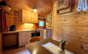 eine Küche mit einem Tisch und einer Holzwand in der Unterkunft Almliesl HOLL-361 in Hollersbach im Pinzgau + 10 Fotos