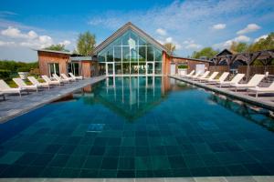 a swimming pool with chairs and a building at Robins Retreat ML55 Lower Mill Estate Cotswolds in Somerford Keynes