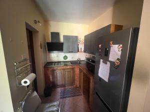 a kitchen with a stainless steel refrigerator and wooden cabinets at Villetta del Sole in La Maddalena
