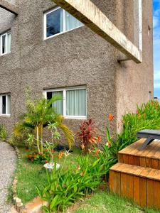 a building with a bunch of plants in front of it at Dourados Villas Suites in São Miguel do Gostoso