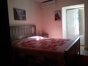 a bedroom with a bed with a red quilt on it at Amaca Iblea in Ragusa