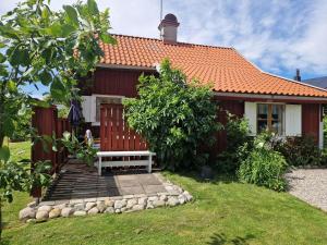 a red house with a bench in front of it at Rustik gäststuga med lantlig känsla nära Örebro city in Örebro