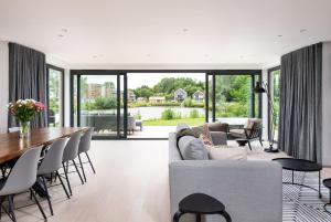 a living room with a couch and a table and chairs at Huron House ML06 Lower Mill Estate Cotswolds in Somerford Keynes