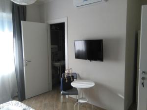 a room with a table and a tv on a wall at My Sweet Rome Guest House in Rome
