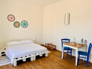 a bedroom with a bed and a table and chairs at Giué in Bovalino Marina