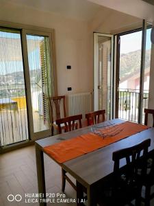 a dining room with a table and a balcony at Casa vacanza il sogno in Furci Siculo