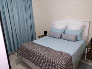 une chambre avec un grand lit avec des rideaux bleus dans l'établissement The Grace House 46A, à East London