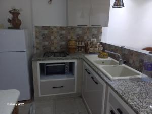 a kitchen with a sink and a stove at maison Sirène in Hammamet +5 photos
