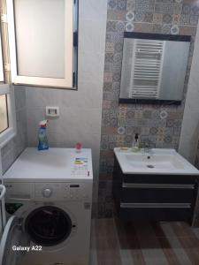 a bathroom with a washing machine and a sink at maison Sirène in Hammamet