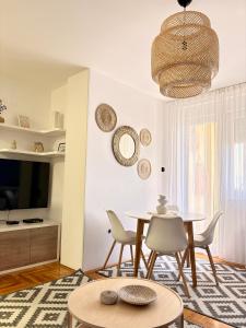 a living room with a table and chairs and a television at Trip Style in Novi Sad
