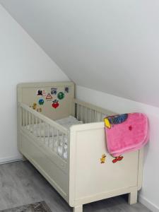 a white crib with a pink bag on top of it at Holiday oasis 120m2 near Legoland Günzburg in Günzburg
