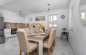 eine weiße Küche mit einem Holztisch und Stühlen in der Unterkunft Cozy Home In Pinezici With Wifi in Pinezici