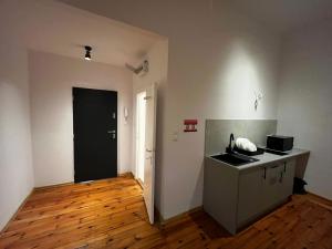 an empty room with a kitchen with a sink and a door at Rynek Loft & Light Rooms in Poznań