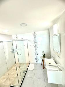 une salle de bain avec douche et lavabo dans l'établissement Luxuosa Cobertura Vista Mar- Praia Grande, à Arraial do Cabo