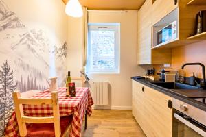 a kitchen with a table with a bottle of wine on it at L'appart Chalet - Sauna - HyperCentre - Ambiance montagne in Rouen