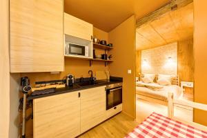 a kitchen with a sink and a microwave and a bedroom at L'appart Chalet - Sauna - HyperCentre - Ambiance montagne in Rouen