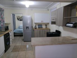 une cuisine avec un réfrigérateur et une table à l'intérieur dans l'établissement The Grace House 46A, à East London