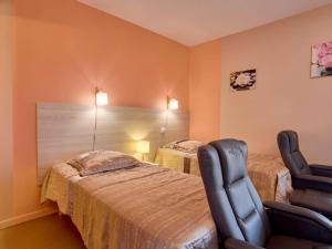 a bedroom with two beds and a chair in it at Studio lumineux proche Lac de l'Uby avec Wi-Fi gratuit - FR-1-841-55 in Barbotan-les-Thermes