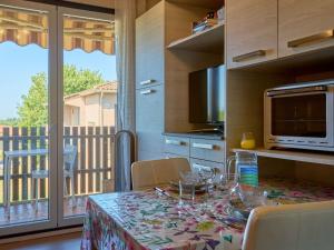 a kitchen with a table with chairs and a balcony at Studio lumineux proche Lac de l'Uby avec Wi-Fi gratuit - FR-1-841-55 in Barbotan-les-Thermes