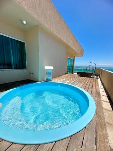 - un bain à remous sur une terrasse avec l'océan en arrière-plan dans l'établissement Luxuosa Cobertura Vista Mar- Praia Grande, à Arraial do Cabo