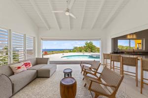 a living room with a couch and chairs and a pool at Dream View Villa in Willemstad