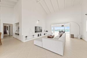 a white living room with a couch and a table at Dream View Villa in Willemstad