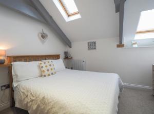 ニューキーにあるSailhouse Loft New Quayの白いベッドと2つの窓がある寝室
