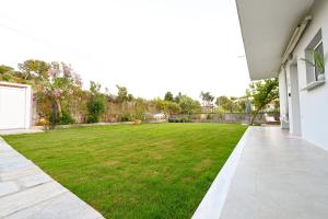 an empty courtyard with a large green lawn at Anchor Villa in Troulos