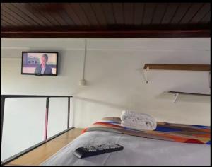 リオデジャネイロにあるApartamento compacto centro Rioのベッドと壁にテレビが掛かった寝室