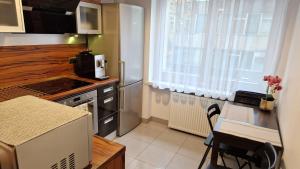 kuchnia z kuchenką, stołem i oknem w obiekcie Apartament Rynek 40m2 Wrocław Stare Miasto we Wrocławiu +13 zdjęć