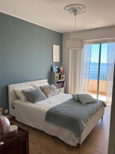 ein Schlafzimmer mit einem Bett mit Blick auf das Meer in der Unterkunft Appartement face à la mer in Santa-Maria-di-Lota