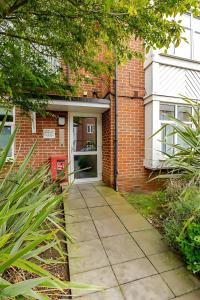 NorwoodにあるBeautiful and Modern 2 Bed Flat in Greater Londonのドアのあるレンガ造りの建物に続く歩道