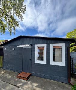 a blue garage with white windows on it at Beach House Mrzeżyno in Mrzeżyno