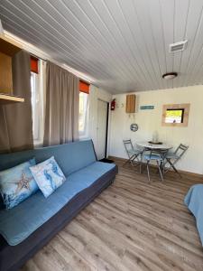 a living room with a blue couch and a table at Beach House Mrzeżyno in Mrzeżyno