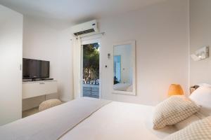 a white bedroom with a bed and a mirror at Magnificent Seafront Villa 10 Bedrooms Pakleni View Villa Private Infinity Pool & Amazing Sea Views Hvar Town in Hvar +32 photos