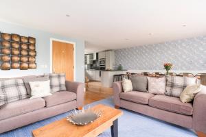 a living room with two couches and a table at Ducklings CW65 Lower Mill Estate Cotswolds in Somerford Keynes