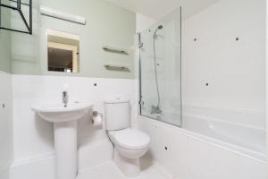 a white bathroom with a toilet and a sink at Ducklings CW65 Lower Mill Estate Cotswolds in Somerford Keynes