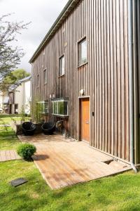 a house with a wooden deck next to a building at Ducklings CW65 Lower Mill Estate Cotswolds in Somerford Keynes