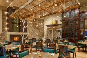 un ristorante con tavoli, sedie e un camino di Varscona Hotel on Whyte a Edmonton