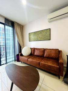 a living room with a brown couch and a table at Harmony Homes at i-City - free WiFi and 1 Car Park in Shah Alam